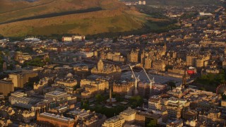 AX112_056 - 5.5K aerial stock footage of Balmoral Hotel and cityscape of Edinburgh, Scotland at sunset