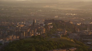 AX112_062E - 5.5K aerial stock footage of passing Edinburgh Castle and cityscape, Scotland at sunset