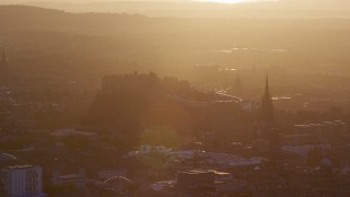 AX112_073E - 5.5K aerial stock footage slowly flyby Edinburgh Castle and The Hub cathedral, Scotland at sunset