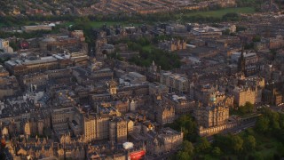 AX112_078E - 5.5K aerial stock footage reverse view of Lloyds Bank Headquarters, reveal Scott Monument and train station, Edinburgh, Scotland at sunset