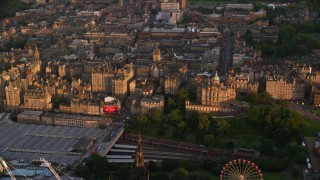 AX112_079 - 5.5K aerial stock footage reverse view of Lloyds Bank Headquarters, reveal Scott Monument and train station, Edinburgh, Scotland at sunset