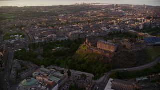 AX112_084E - 5.5K aerial stock footage of flying by cityscape and Edinburgh Castle, Scotland at sunset