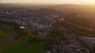 AX112_091E - 5.5K aerial stock footage of following Canongate toward Edinburgh Castle, Scotland at sunset