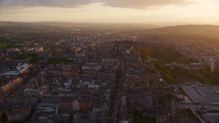 AX112_095E - 5.5K aerial stock footage fly over iconic Edinburgh Castle, Scotland at sunset