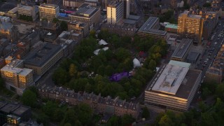AX112_100 - 5.5K aerial stock footage of orbiting George Square Gardens, University of Edinburgh, Scotland at sunset