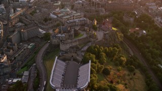 AX112_107 - 5.5K aerial stock footage approach and fly over Edinburgh Castle, Scotland at sunset