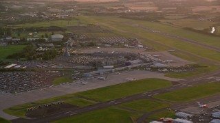 AX112_116 - 5.5K aerial stock footage of flying by Edinburgh Airport, Scotland at sunset