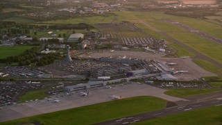 AX112_117 - 5.5K aerial stock footage video of passing by Edinburgh Airport at sunset, Scotland
