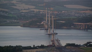 AX112_126 - 5.5K aerial stock footage of passing a bridge under construction, Edinburgh, Scotland at sunset