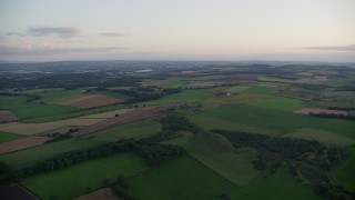 AX112_130 - 5.5K aerial stock footage of green farm fields, Broxburn, Scotland at sunset