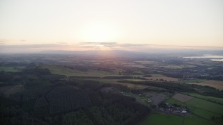 AX112_135E - 5.5K aerial stock footage of sun setting over farmland, Linlithgow, Scotland