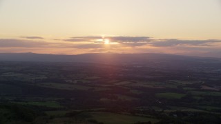 AX112_137 - 5.5K aerial stock footage of the setting sun over farmland in Linlithgow, Scotland