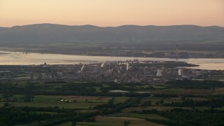 AX112_141 - 5.5K aerial stock footage of a natural gas power plant beside the water, Falkirk, Scotland at sunset