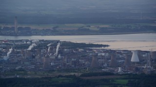 AX112_144E - 5.5K aerial stock footage flyby natural gas plant by the water, Falkirk, Scotland at twilight