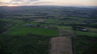 AX112_155 - 5.5K aerial stock footage of passing farms and fields in Bonnybridge, Scotland at twilight