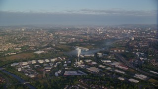 AX113_001E - 5.5K aerial stock footage of flying by warehouses and  the cityscape of Glasgow, Scotland at sunrise