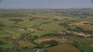 AX113_005 - 5.5K stock footage aerial video of farms, fields and rural homes near A726 Highway, Glasgow, Scotland at sunrise
