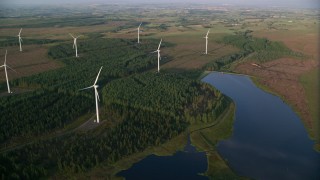 AX113_019 - 5.5K stock footage aerial video fly over windmills and the Craigendunton Reservoir, Eaglesham, Scotland at sunrise