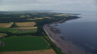 AX113_053 - 5.5K aerial stock footage fly over farm fields and beach along Firth of Clyde, Maybole, Scotland