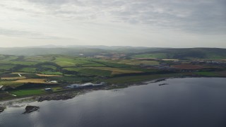 AX113_066 - 5.5K aerial stock footage of passing the coastline and farms along Firth of Clyde, Girvan, Scotland