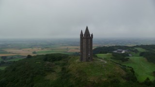 AX113_137 - 5.5K aerial stock footage of orbiting Scrabo Tower atop a green hill, Newtownards, Northern Ireland