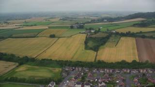 AX113_138E - 5.5K aerial stock footage flying by farm fields, reveal shoreline, Newtownards, Northern Ireland