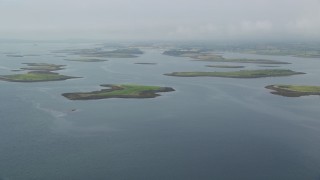 AX113_140E - 5.5K aerial stock footage of an approach to islands in a sea loch, Strangford Lough in Northern Ireland