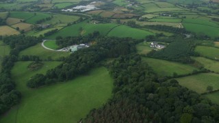AX113_162E - 5.5K aerial stock footage fly over farms and green fields, Downpatrick, Northern Ireland