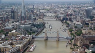 AX114_093E - 5.5K aerial stock footage orbit the Tower Bridge on River Thames near skyscrapers, Central London, England