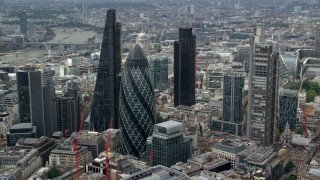 AX114_106 - 5.5K stock footage aerial video of orbiting around The Gherkin and city skyscrapers, Central London, England