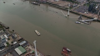 AX114_142E - 5.5K aerial stock footage of orbit Emirates Air Line gondolas and reveal The O2 arena, London, England
