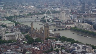 AX114_175E - 5.5K aerial stock footage of Big Ben, Parliament, and London Eye beside the River Thames, England