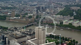 AX114_183 - 5.5K stock footage aerial video of iconic Big Ben, British Parliament and London Eye by River Thames, England