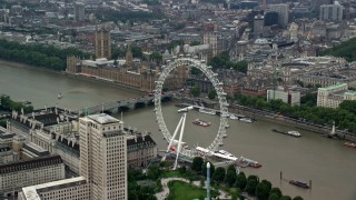 AX114_184 - 5.5K stock footage aerial video of London Eye with Big Ben and British Parliament in the background, England