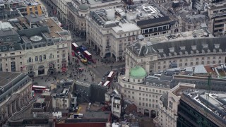 AX114_234E - 5.5K aerial stock footage of an orbit of Piccadilly Circus and double decker buses, London, England