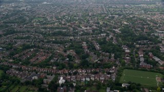 AX114_276E - 5.5K aerial stock footage of residential neighborhoods and Saint Benedict's Abbey, London, England