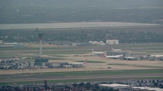 AX114_287 - 5.5K aerial stock footage of the control tower and airliner at London Heathrow Airport, England