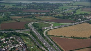 AX114_324E - 5.5K aerial stock footage of orbiting M4 Freeway Interchange by farmland, Windsor England