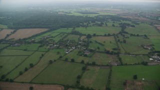 AX114_331 - 5.5K aerial stock footage of flying over rural homes and farmland, Windsor, England