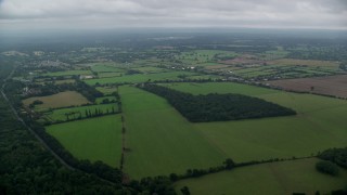 AX114_333E - 5.5K aerial stock footage of flying over a rural landscape with farm fields in Windsor, England