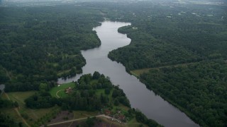 AX114_344E - 5.5K aerial stock footage of flying over Virginia Water Lake toward homes, England