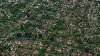 AX114_369E - 5.5K aerial stock footage tilt from homes to reveal farm fields, Leatherhead, England