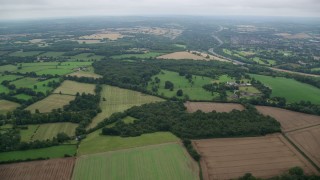 AX114_378 - 5.5K aerial stock footage of flying over fields and trees, Tadworth, England