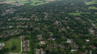 AX114_386 - 5.5K aerial stock footage of flying over homes among trees, Redhill, England