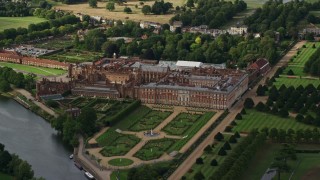 AX115_030E - 5.5K aerial stock footage of an orbit of Hampton Court Palace by the River Thames, Moseley, England