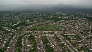 AX115_049 - 5.5K aerial stock footage fly over suburban homes with rain in the distance, London, England