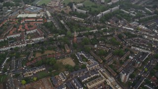 AX115_057 - 5.5K aerial stock footage tilt to St John the Divine church by apartment buildings in the rain, London, England