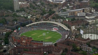 AX115_058 - 5.5K aerial stock footage of orbiting The Oval cricket stadium in the rain, London, England