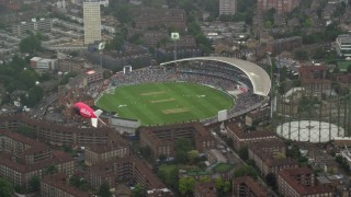 AX115_059 - 5.5K aerial stock footage of orbiting The Oval cricket stadium in the rain, London, England
