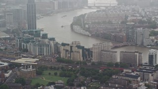 AX115_060 - 5.5K aerial stock footage of orbiting MI6 Building in the rain, London, England